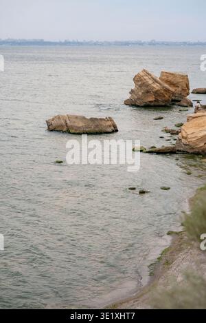 Ruhige Meereslandschaft mit großen Felsen im Wasser in der Nähe eines Sandstrandes. Konzept der maritimen Natur Schönheit, friedliche Sommeratmosphäre und Ruhe Stockfoto