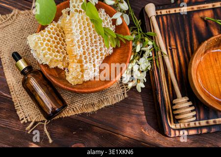 Ein blühender Baum zeigt duftende Blüten, die Bienen auf der Suche nach Nektar anziehen. Honigwaben und Honig werden zur Abholung in der Nähe platziert. Diese Szene ist hochgradig Stockfoto