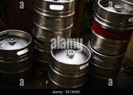 Eine professionelle Hochwinkelaufnahme mehrerer Aluminium-Bierfässer, die zusammen gestapelt sind. Das Bild hebt den metallischen Glanz und die zylindrischen Formen der Ba hervor Stockfoto