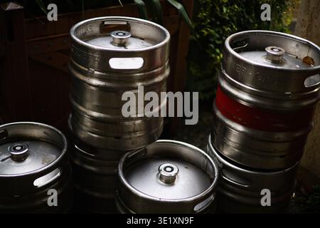 Eine professionelle Hochwinkelaufnahme mehrerer Aluminium-Bierfässer, die zusammen gestapelt sind. Das Bild hebt den metallischen Glanz und die zylindrischen Formen der Ba hervor Stockfoto