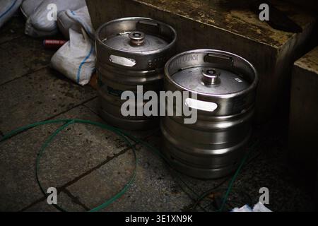 Eine professionelle Hochwinkelaufnahme mehrerer Aluminium-Bierfässer, die zusammen gestapelt sind. Das Bild hebt den metallischen Glanz und die zylindrischen Formen der Ba hervor Stockfoto