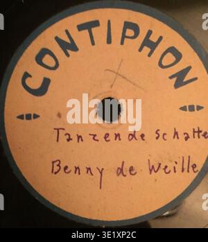 Die Contiphon Gelatine-Schallplatte Tanzende Schatten, Benny de Weille ist eine selbstaufnehmende Gelatine-Schallplatte der Continental-Gelatine-Industrie GmbH in Michelstadt, Odenwald, Hessen um 1945. Das Archivfotogramm dokumentiert das Etikett für die Katalogisierung. Der historische Fotodruck bewahrt die frühe Audioaufzeichnungstechnologie für Inventarzwecke. Stockfoto