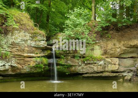 Der Wasserfall fließt über Felsformationen in einen ruhigen Pool, der von üppig grünen Wäldern in Stvolinky umgeben ist Stockfoto