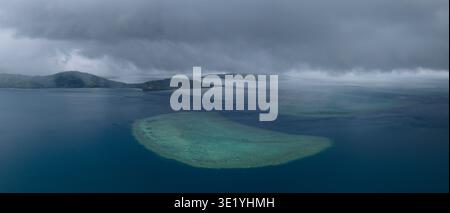 Regen zieht über ein Korallenriff in der Nähe der Küste von Viti Levu auf Fidschi. Fidschis Riffe weisen eine hohe biologische Vielfalt der Meere auf und sind ein beliebtes Touristenziel. Stockfoto
