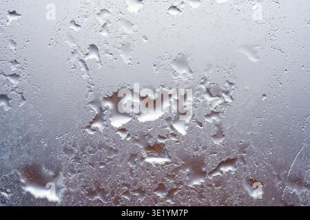 Nahaufnahme von Wassertröpfchen auf Glasoberfläche mit verschwommenem Hintergrund. Stockfoto