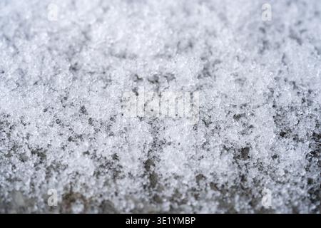 Nahaufnahme der Textur der Schneeoberfläche mit Eiskristallen und Winterhintergrund. Stockfoto