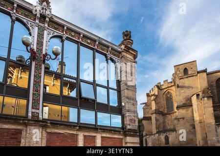 Spiegelbild eines Hauses an den Fenstern des überdachten Marktes und der Kathedrale von Narbonne in Frankreich Stockfoto