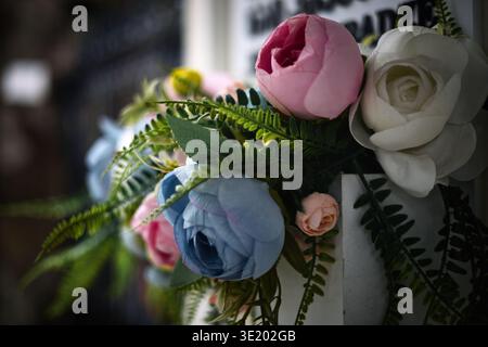 Professionelle Nahaufnahme eines zarten Blumenarrangements mit realistischen künstlichen Pfingstrosen und Rosen in weichen Pastelltönen. Die Zusammensetzung, Stockfoto