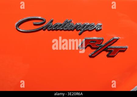 Nahaufnahme eines 1970 Dodge Challenger R/T American Muscle Car-Aufklebers auf leuchtend orangefarbenem Hintergrund. Stockfoto