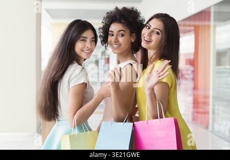 Schönes Mädchen im Kleid, das Einkaufstaschen hält Stockfoto