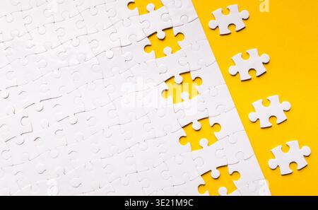 Collage von Puzzleteilen auf gelbem Hintergrund, die eine Sammlung für ein kreatives Projekt zeigen Stockfoto