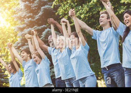 Melden Sie Gruppe von jungen Freiwilligen Hände in Park Stockfoto