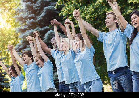 Melden Sie Gruppe von jungen Freiwilligen Hände in Park Stockfoto