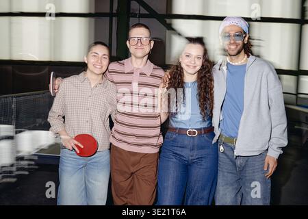 Eine Gruppe junger multiethnischer Erwachsener, die zusammen lächelt und drinnen posiert Stockfoto