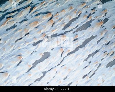 Abstrakte Luftaufnahme von Sandmustern mit dunklen Mineralstreifen in der argentinischen Puna-Wüste, Argentinien. Stockfoto