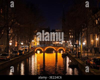 Die Kanalszenen in Amsterdam sind bei Nacht wunderschön beleuchtet. Stockfoto