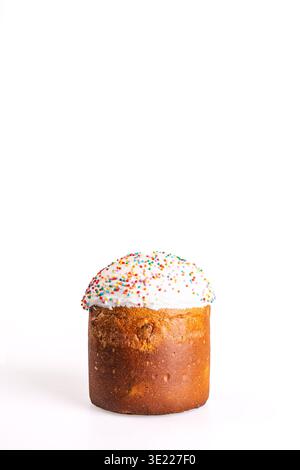 Traditionelles Osterkulich mit goldener Kruste und glänzend weißer Glasur, gekrönt mit hellen mehrfarbigen Streuseln, isoliert auf sauberem weißem Hintergrund Stockfoto