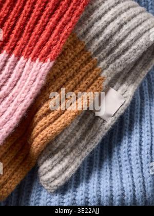 Bunte Strickschals mit roten, rosa, orangen, grauen und blauen Stofftexturen. Deutschland Stockfoto