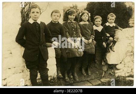 Edwardians Postkarte aus den 1900er Jahren mit einer Gruppe glücklicher Kinder, die mit ihren Cousins auf dem Land Urlaub machen, Edwardians Mode aus den 1900er Jahren. Ca. 1910 / 1910er Jahre Stockfoto