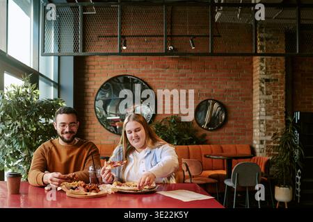 Junger Mann und Frau, die zusammen ein Mittagessen in einem modernen Café genießen Stockfoto