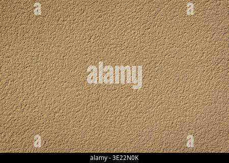 Nahaufnahme einer beigefarbenen Stuckwand mit feiner, rauer Textur. Stockfoto