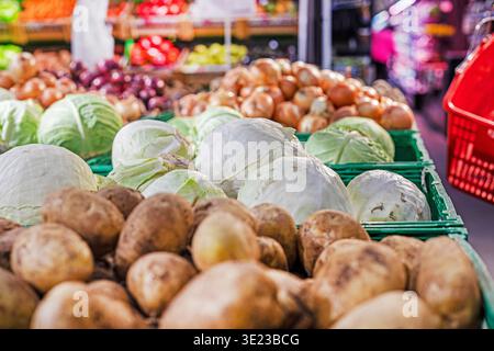 Gemüse, Kartoffeln, Kohl und Zwiebeln in Plastikbehältern im Supermarkt Stockfoto