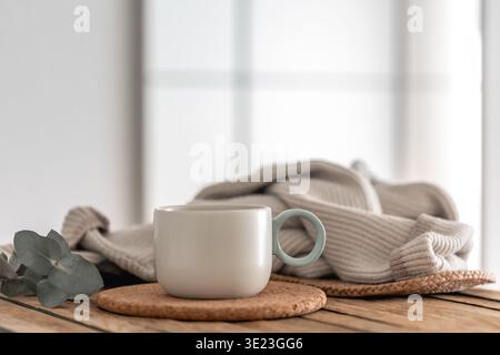 Becher und Grün auf Holztisch für einen ruhigen Morgen. Einfaches Ritual. Stockfoto