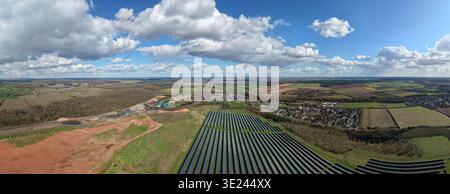 Die Solarpaneele und die Biogasanlage aus der Vogelperspektive stehen unter einem weiten Himmel im Kontrast zur Stadt Meden Vale in Meden Vale, Großbritannien. Stockfoto