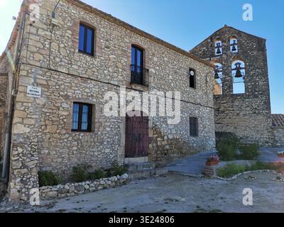 Rustikales Steinhaus und alter Kirchturm im Dorf Castellet, Spanien. Stockfoto