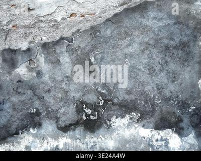 Verwitterte und verwitterte graue Betonwandstruktur mit abblätternder Farbe und Rissen Stockfoto