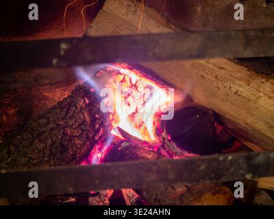 Aus nächster Nähe sehen Sie Brennholz, das Feuer fängt und die komplizierte Struktur der Rinde und die intensive Hitze der glühenden Glut zeigt. Diese atmosphärische Aufnahme fängt ein Stockfoto