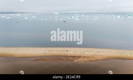 Grönlandstrand mit Eisbergen, die in der Disko Bay schwimmen Stockfoto