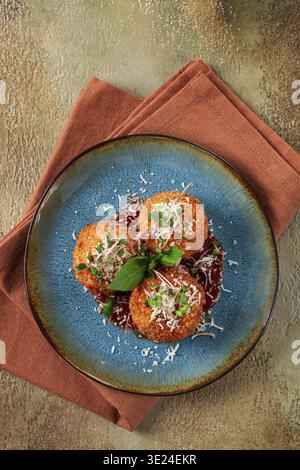 Knusprige Arancini-Vorspeise mit Parmesan und Mikrogrün, Teller, Tomatensauce, hausgemacht, keine Leute Stockfoto