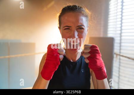 Aufschrei unabhängiger Mädels Macht. Wütende, starke, verrückte Kämpferin, die aggressiv auf Boxring aussieht. Mächtig ehrgeizig, siegreich, selbstbewusst, erfolgreich, weiblich und emotional energisch Stockfoto