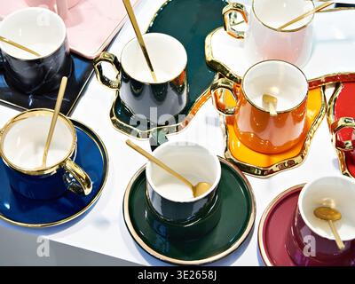 Farbige Teetassen aus Porzellan mit Löffeln Stockfoto