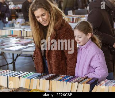 Mutter und Tochter lächeln auf der Suche nach Büchern auf dem Soth Bank Buchmarkt in London Stockfoto