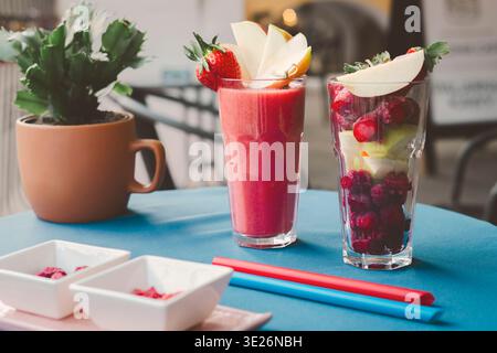 Frische Erdbeeren-Smoothies in Gläsern auf einem Holztisch. Gesundes Sommergetränk, Bio-Fruchtgetränk, leuchtend rosa Farbe, natürliche Zutaten Stockfoto