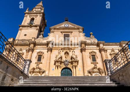 Perspektivischer Blick auf die St. John the Baptist Cathedral in Ragusa. Die spätbarocke Fassade aus dem 18. Jahrhundert ragt über eine monumentale Treppe, die von Eisen eingerahmt ist Stockfoto