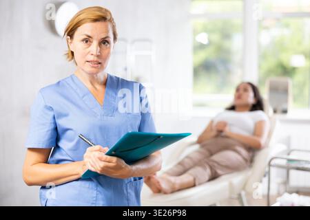 Porträt eines Arztes mittleren Alters mit Dokumenten Stockfoto