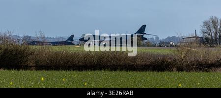 Blick auf die strategischen Überschallbomber B-1B Lancer, die auf der Fluglinie am Luftwaffenstützpunkt RAF Fairford geparkt sind, von einem grasbewachsenen Feld aus gesehen Stockfoto