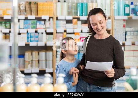 Die Frau hält ein ärztliches Rezept in der Nähe eines Kindes Stockfoto