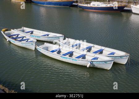 Kleine Ruderboote der Sea Cadets liegen zusammen in Lydney Harbour, Gloucestershire, England Stockfoto