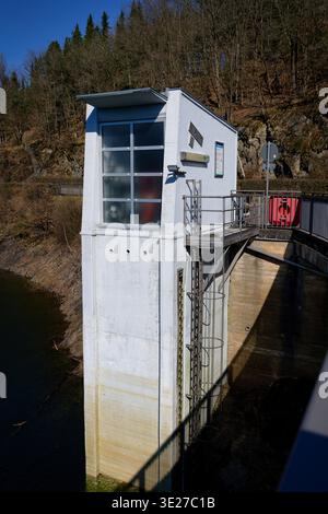 Technisches Kontrollgebäude am Olef-Damm in Hellenthal. Ansicht mit Wasserstandsanzeige, Leiter und umliegenden Wäldern an einem sonnigen Tag Stockfoto