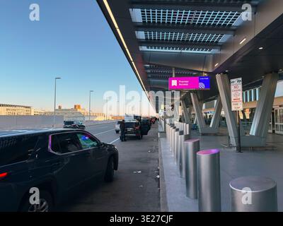 Absetzbereich am Flughafen Newark Liberty am Terminal C mit Fahrzeugen, Pollern und United Premier Access-Schildern Stockfoto