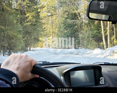 Reisen Sie durch Winterstraßen mit Blick vom Auto auf die ländliche Landschaft während eines Roadtrips im Frühjahr Stockfoto