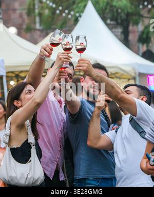 Bei den Weintagen in Jerewan heben Freunde gemeinsam ihre Weingläser auf, während sie mitten in der Menge ein Foto machen. Stockfoto