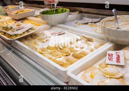 Genua, ligurien, italien. Mai 2024. Frische Ravioli, Pansoti und verschiedene handgemachte Nudelgerichte werden an einem Marktstand in genua ausgestellt, zum Kauf bereit und zum Kochen Stockfoto
