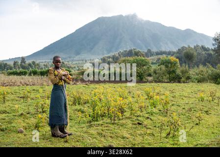 Mädchen vor Mount Sabyinyo, Vulkan-Nationalpark, Ruanda Stockfoto