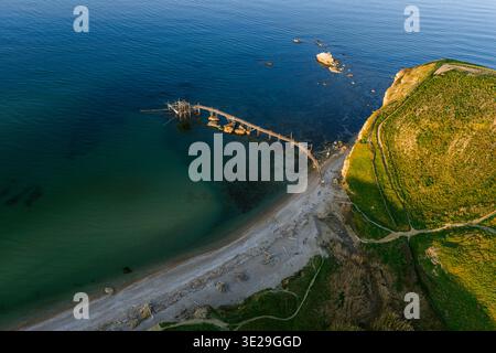 Aus der Vogelperspektive der Trabocchi Küste treffen auf das türkisfarbene Meer, im Kontrast zur üppigen grünen Landzunge von Punta Aderci, riesig Stockfoto