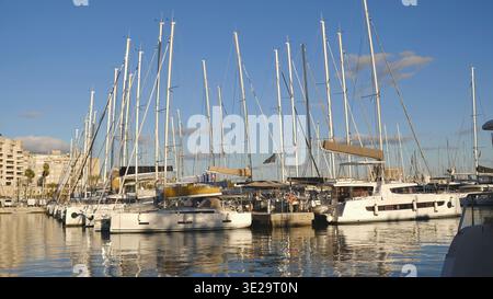 Moderne Segelyachten und Katamarane, die in einem sonnigen Yachthafen vertäut sind. Für Luxusreisen, Charter, Immobilien am Wasser und Lifestyle-Marketing. Stockfoto
